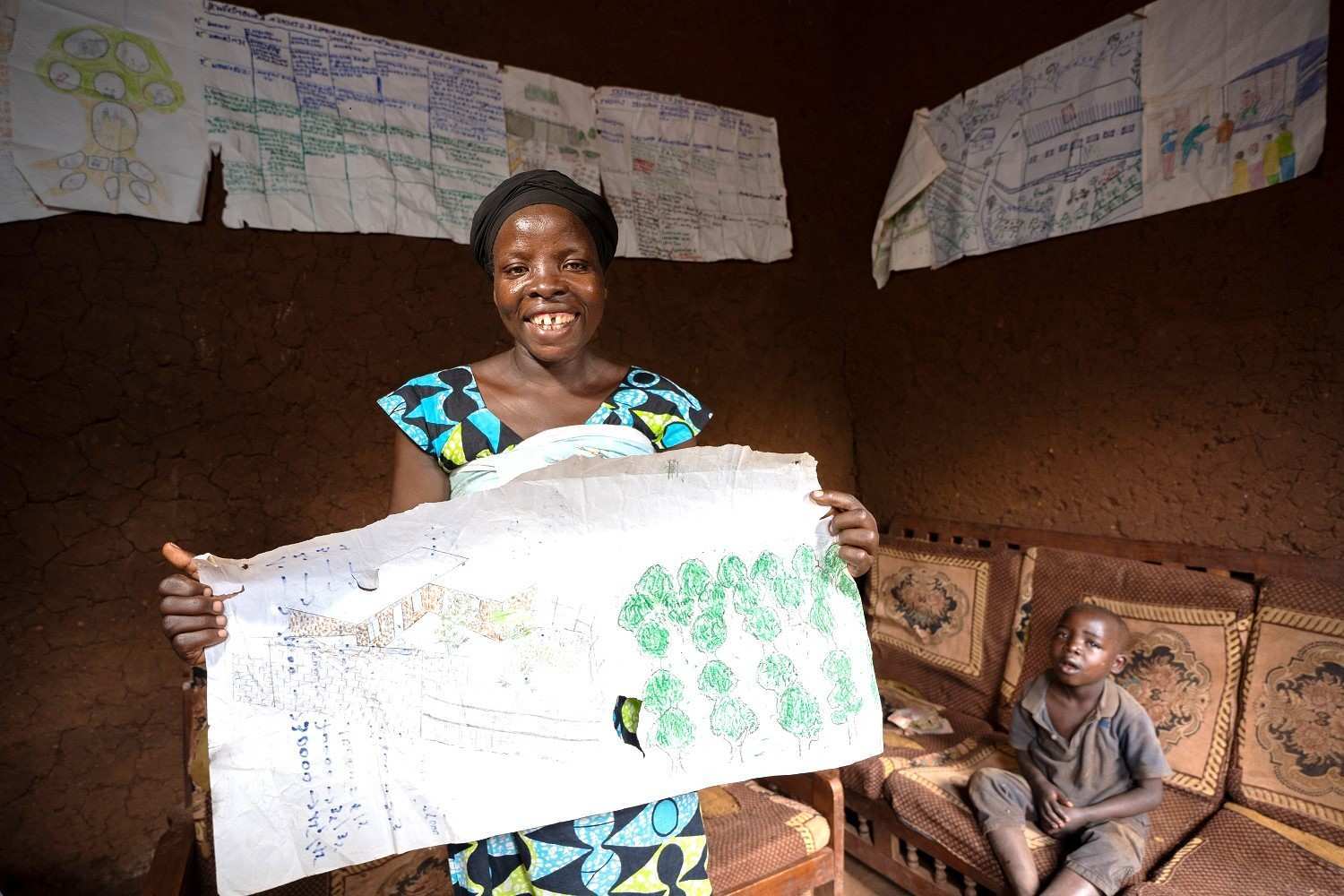 Eine Frau hält einen großen bemalten Plan hoch - an den Wänden hängen rundherum weitere Pläne (Quelle: Christian Nusch) Eine Frau hält einen großen bemalten Plan hoch - an den Wänden hängen rundherum weitere Pläne (Quelle: Christian Nusch)