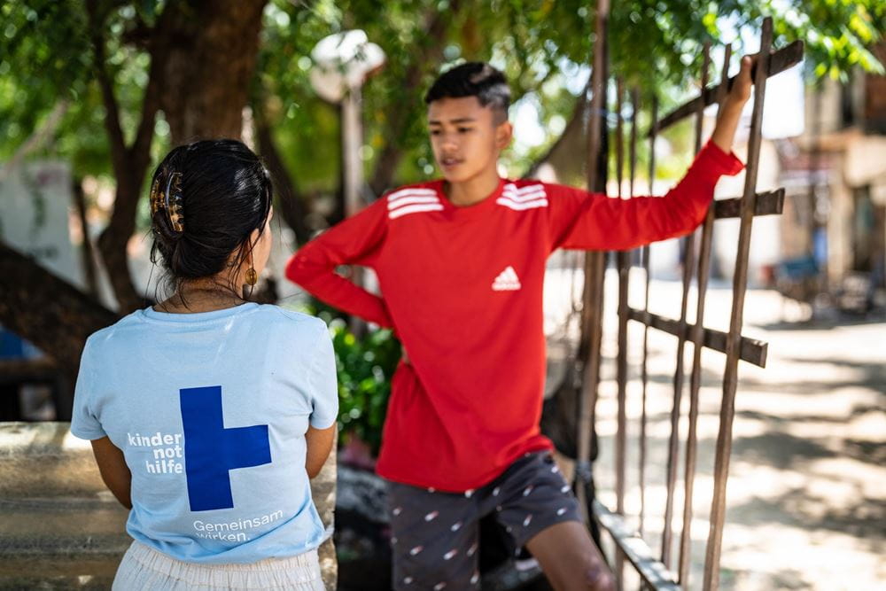Eine Kindernothilfe-Mitarbeiterin im Gespräch mit einem Jugendlichen in einer Favela in Brasilien (Foto: Jakob Studnar) Platzhalterbild