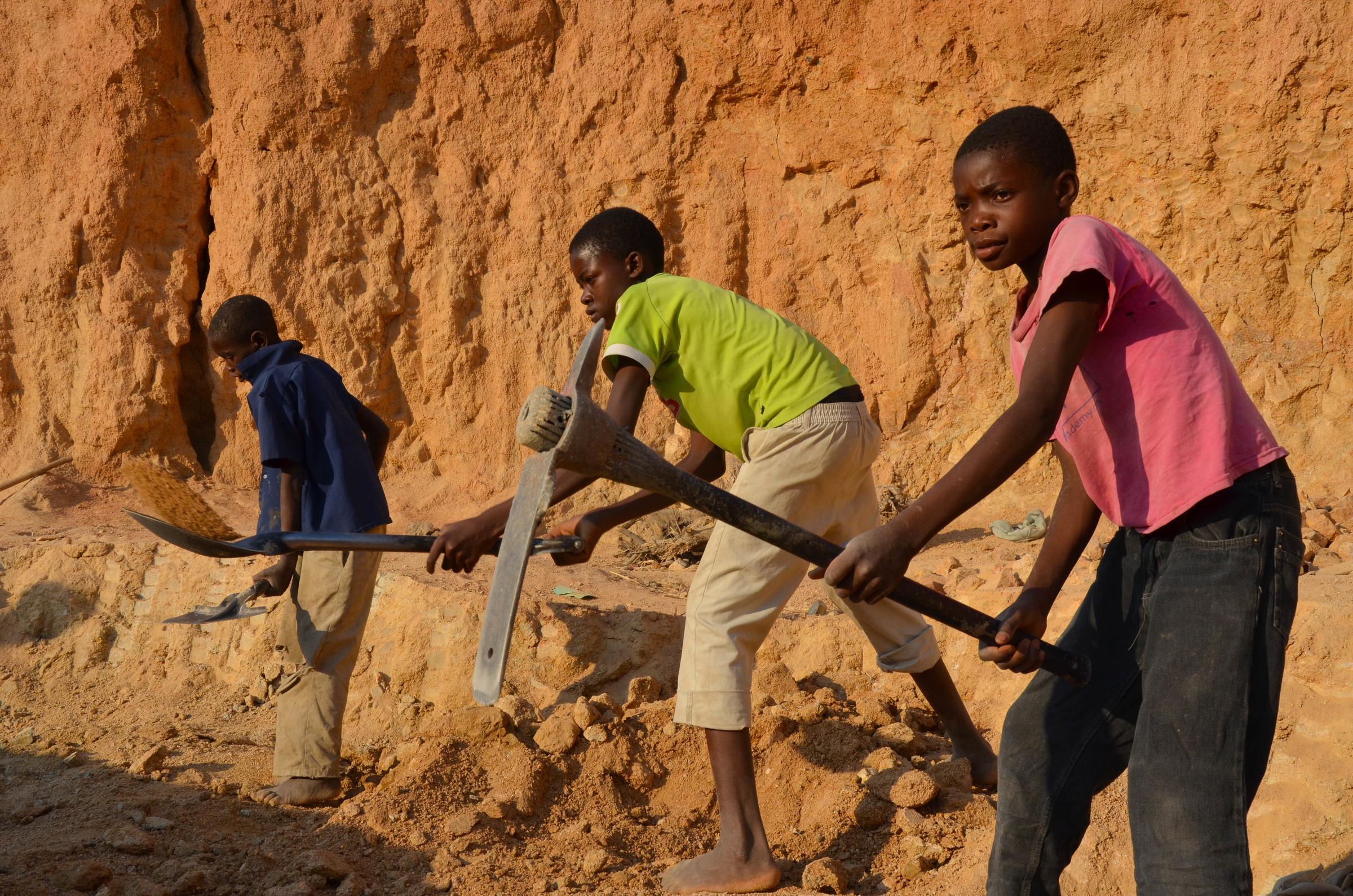 Kinder arbeiten mit Hacken und Schaufeln in Sambia Kinder arbeiten mit Hacken und Schaufeln in Sambia