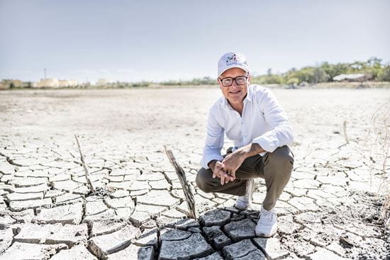 Kindernothilfe-Botschafter und Meteorologe Karsten Schwanke betrachtet in einem ausgetrockenem See die negativen Auswirkungen des menschengemachten Klimawandels auf die Umwelt. Foto: Jakob Studnar für KNH. Kindernothilfe-Botschafter und Meteorologe Karsten Schwanke betrachtet in einem ausgetrockenem See die negativen Auswirkungen des menschengemachten Klimawandels auf die Umwelt. Foto: Jakob Studnar für KNH.