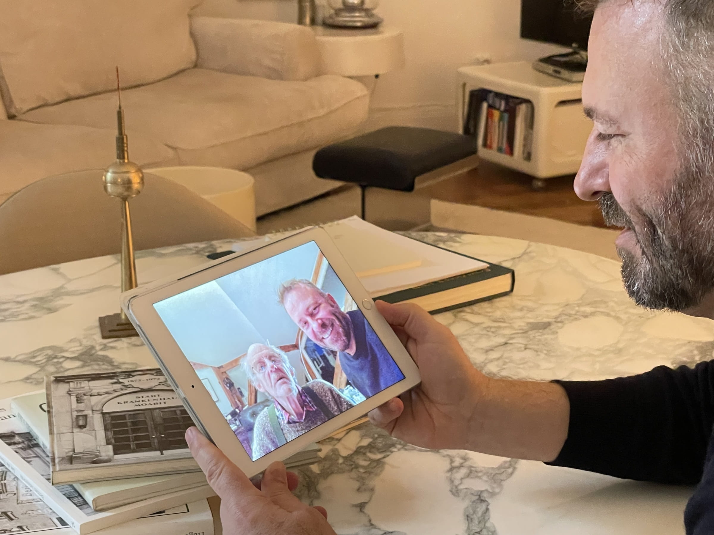 Oliver Geiger schaut auf ein gemeinsames Bild mit Volker Gebert in dessen Wohnung, Dezember 2023 (Quelle: Kindernothilfe)