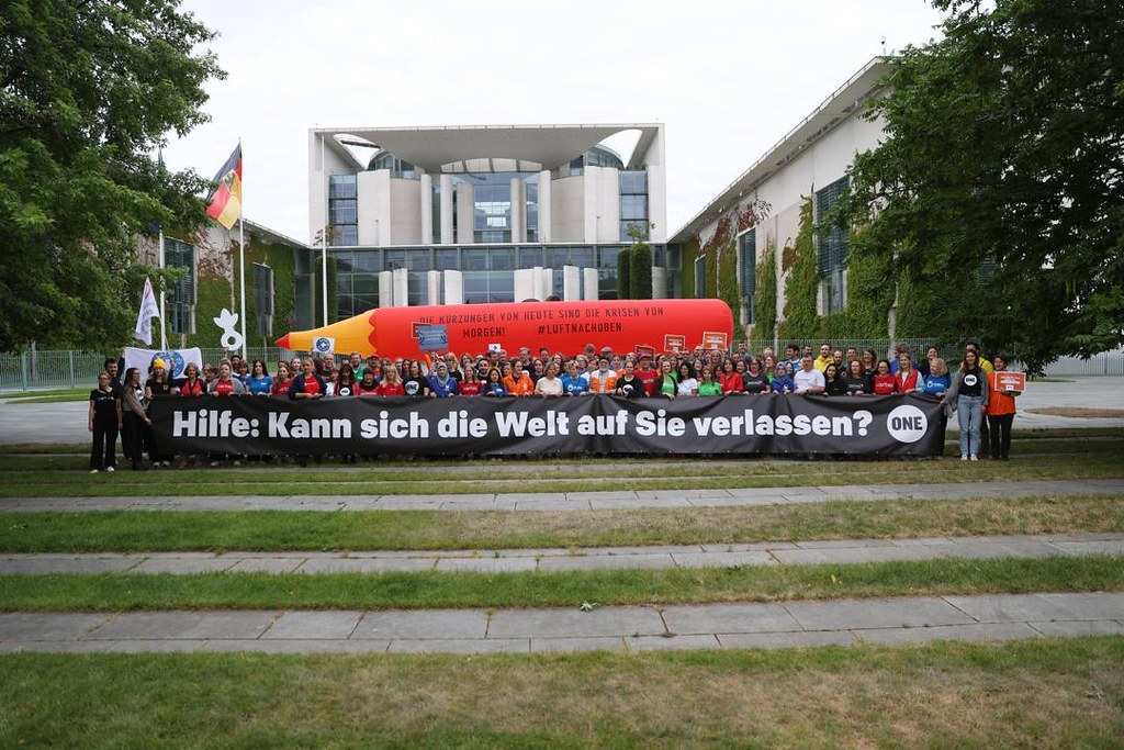 Gemeinsame Protestaktion mit 12-Meter-Rotstift vor dem Kanzleramt (24.06.2025) (Quelle: One Campaign) Gemeinsame Protestaktion mit 12-Meter-Rotstift vor dem Kanzleramt (24.06.2025) (Quelle: One Campaign)