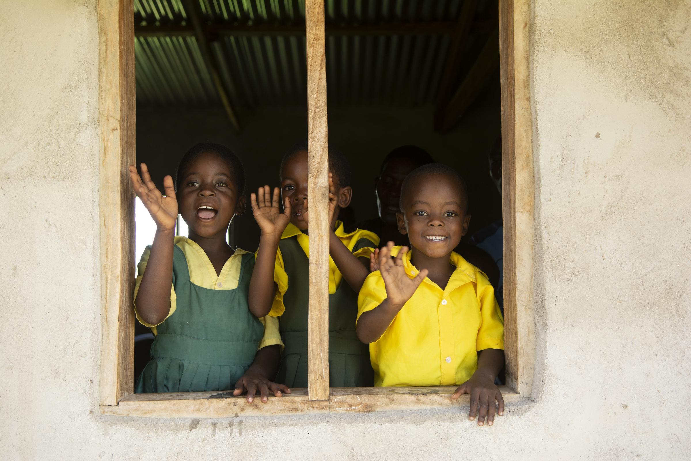Kinder aus Malawi winken aus einem Schulfenster (Quelle: Christian Nusch)