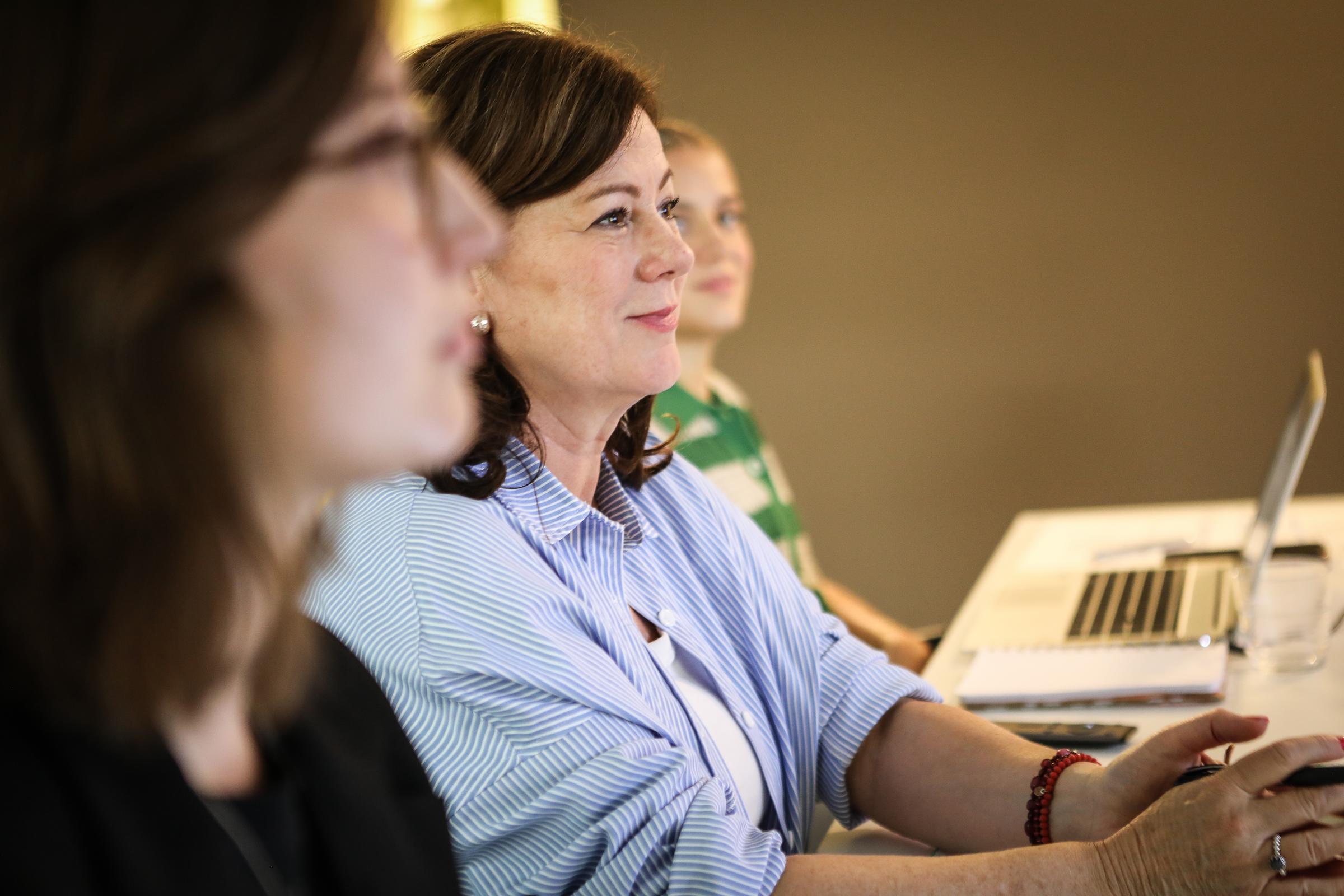 Drei Mitarbeiterinnen der Kindernothilfe im Seitenprofil sitzen an einem Tisch (Quelle: Kindernothilfe)
