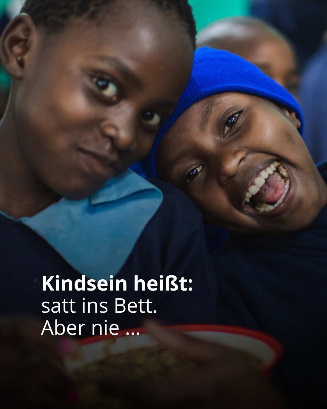 Kinder schauen in die Kamera und lächeln. Auf dem Bild steht der Text: Kindsein heißt: satt ins Bett. Aber nie..." (Foto: Kindernothilfe)