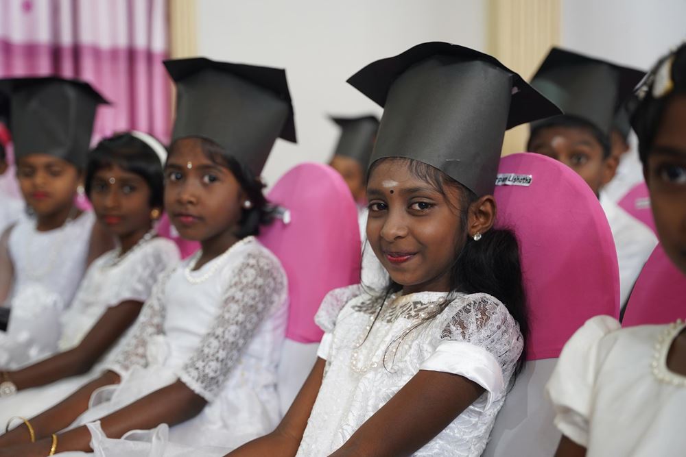 Mädchen aus Sri Lanka bei ihrer Abschlusszeremonie in weißen Kleidern mit selbstgebastelten Abschlusshüten (Quelle: Christian Nusch) Mädchen aus Sri Lanka bei ihrer Abschlusszeremonie in weißen Kleidern mit selbstgebastelten Abschlusshüten (Quelle: Christian Nusch)