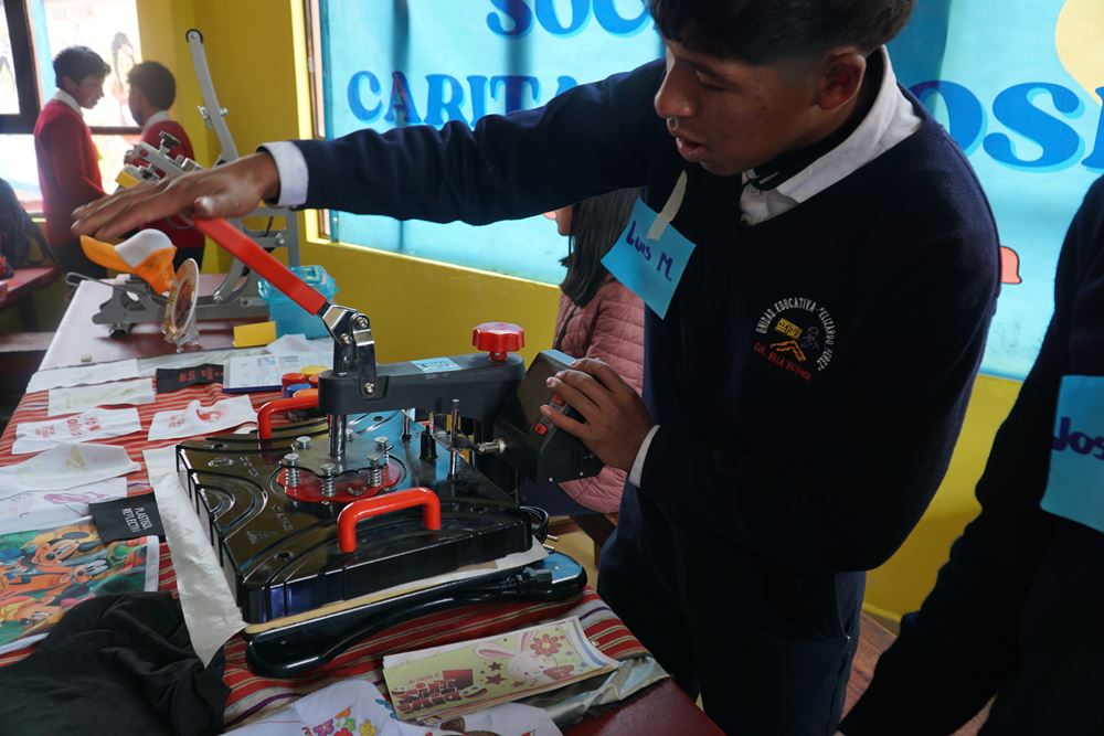 Ein Junge aus Bolivien druckt mit einer Maschine Muster auf Stoffmaterialien (Foto: privat) Ein Junge aus Bolivien druckt mit einer Maschine Muster auf Stoffmaterialien (Foto: privat)