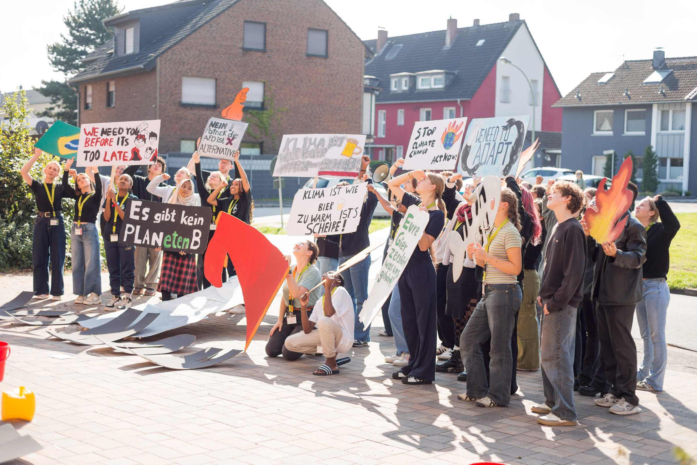 Die Jugendlichen auf der Jugendkonferenz mit selbstgebastelten Plakaten mit Klimabotschaften und -forderungen (Quelle: Finn Schäfer)