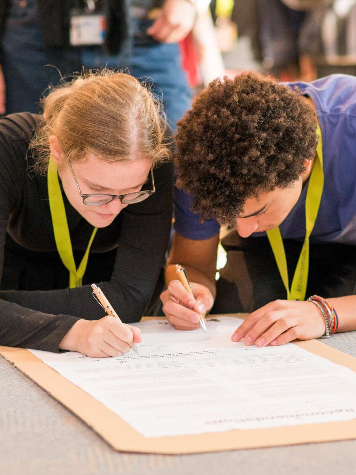 Jugendliche unterschreiben eine Petition auf der Jugendkonferenz (Quelle: Finn Schäfer)