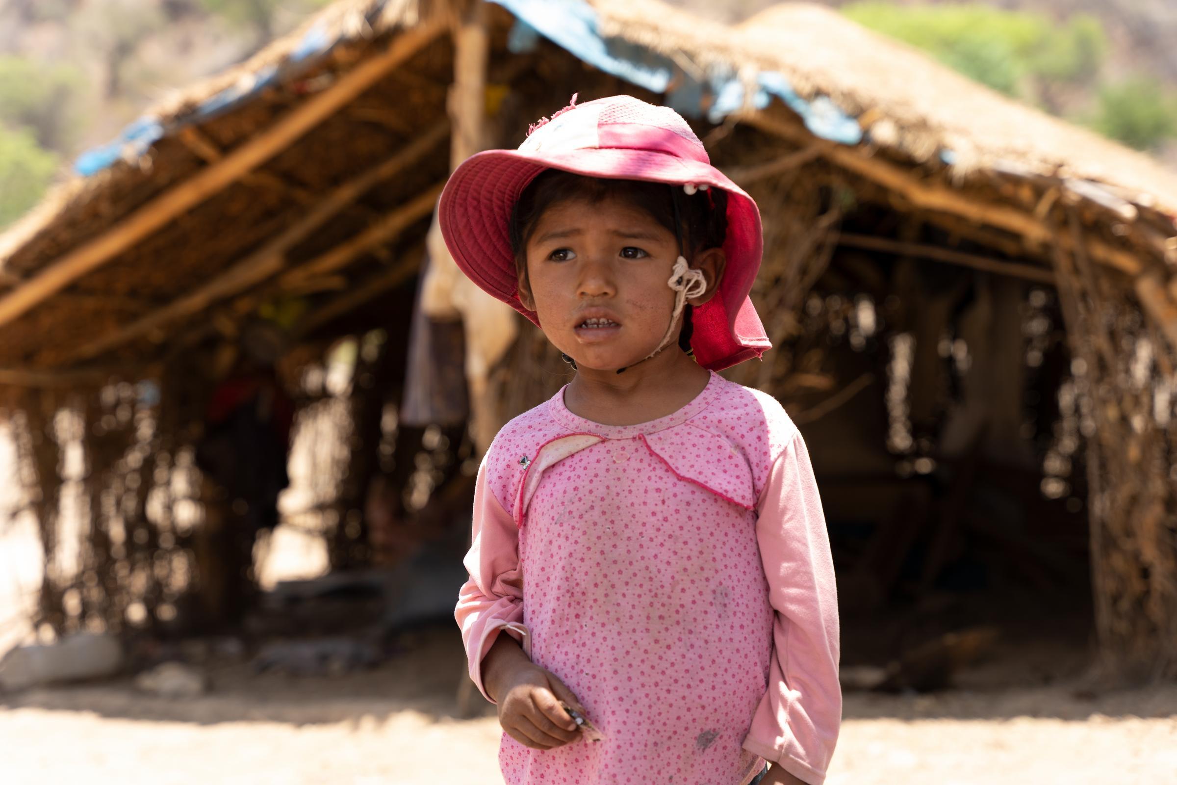 Die kleine Wayra steht vor einer einfachen Zelt-Hütte