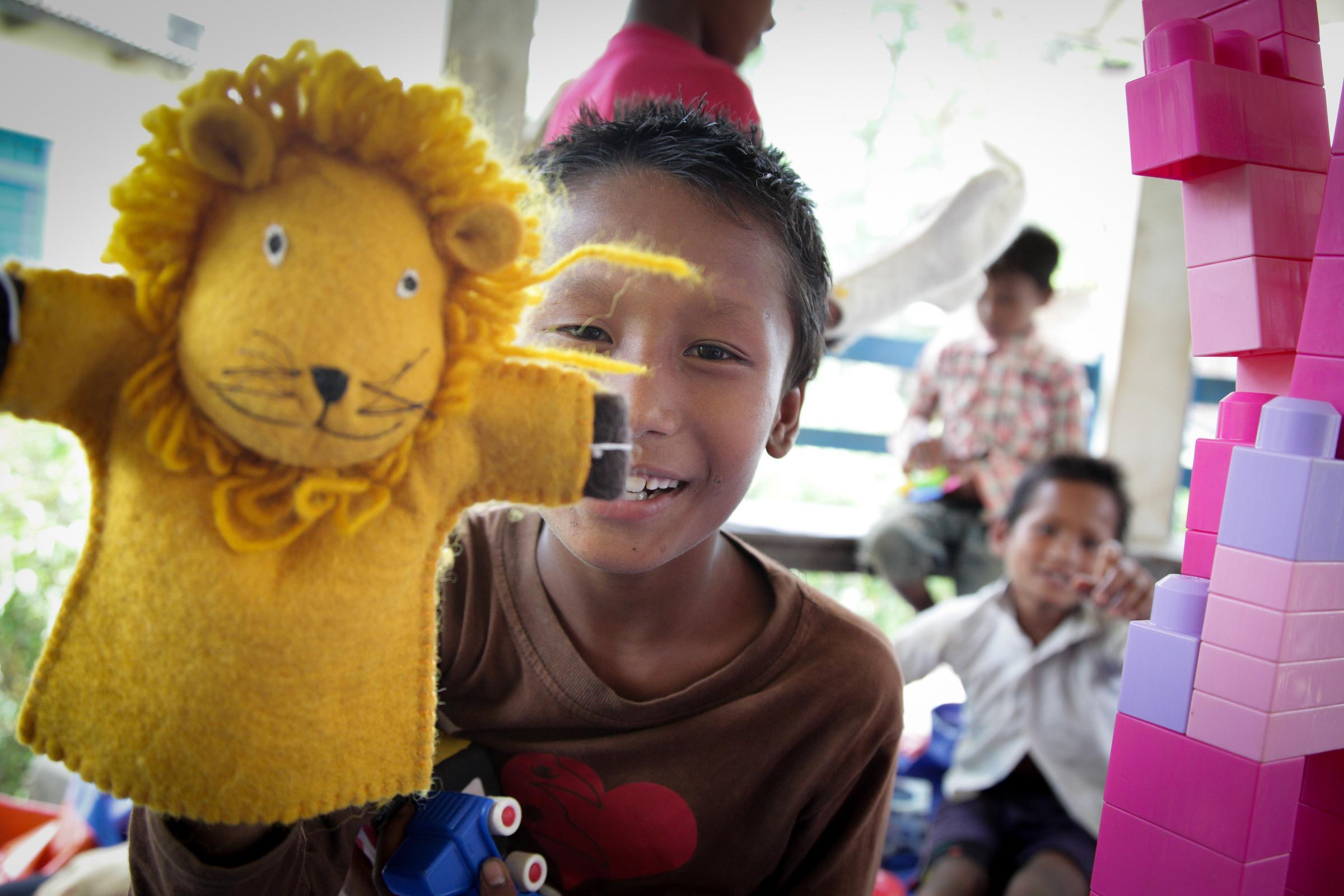 Nepal: Pressereise - Mit Löwen-Marionette spielender Junge