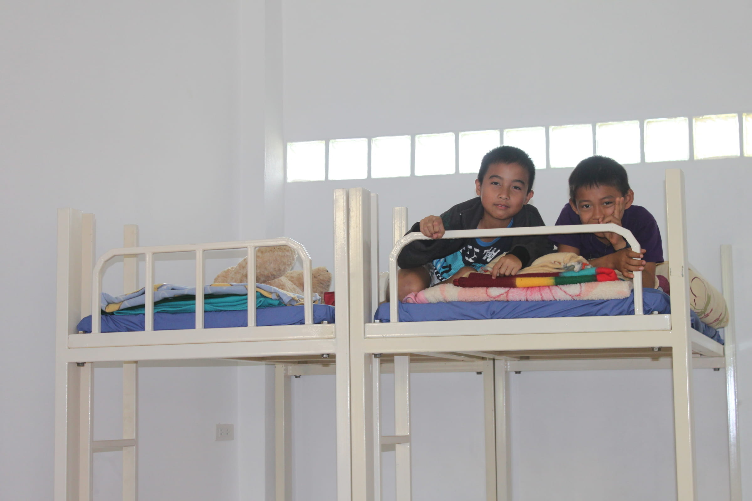 Zwei glückliche Jungen strahlen aus ihrem Stockbett Zwei glückliche Jungen strahlen aus ihrem Stockbett