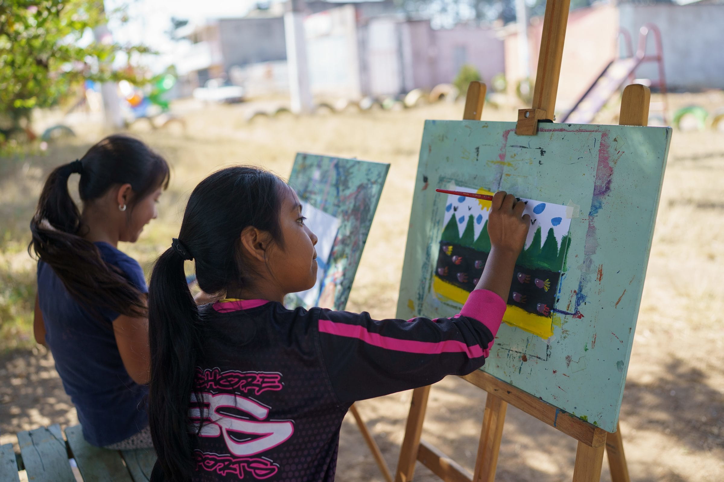 Zwei Mädchen aus Guatemala malen Bilder auf Staffeleien (Quelle: James Rodríguez)