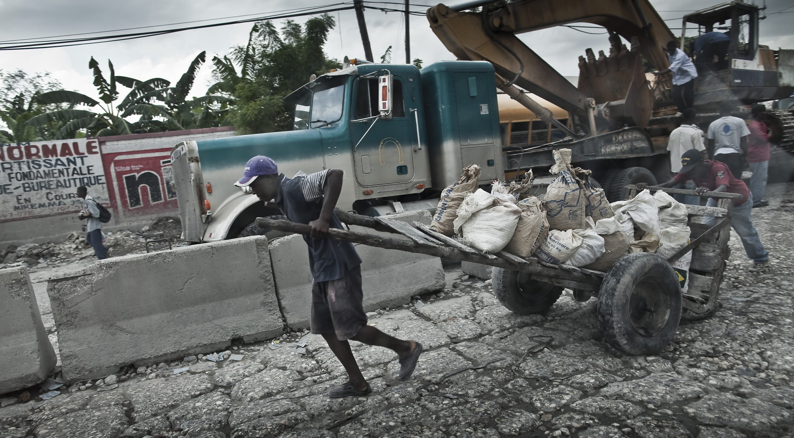 Ein Mann in Haiti zieht einen schwer beladenen Karren. (Quelle: Jakob Studnar)