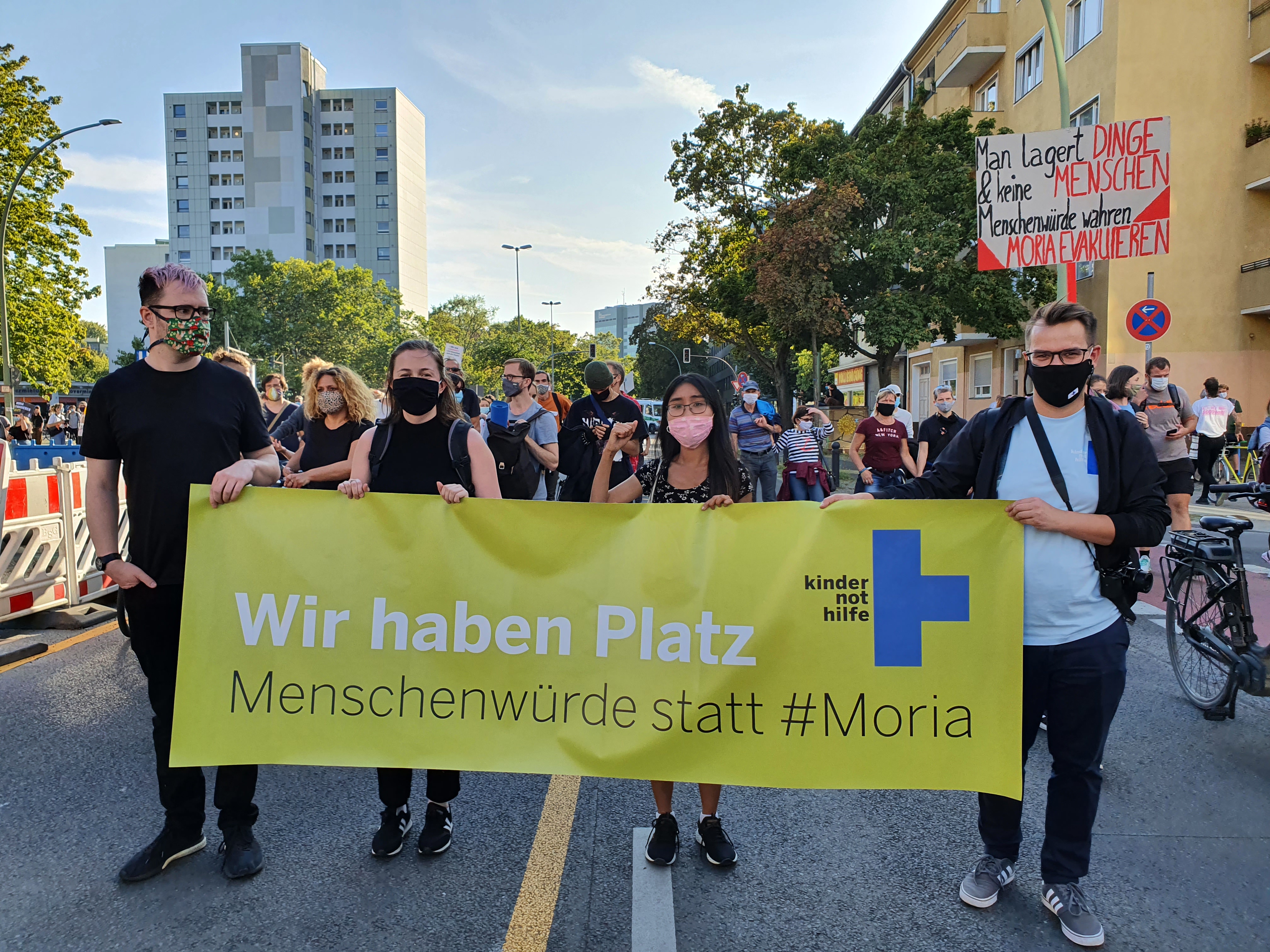 Ehrenamtliche halten Kindernothilfe-Banner bei Demonstration