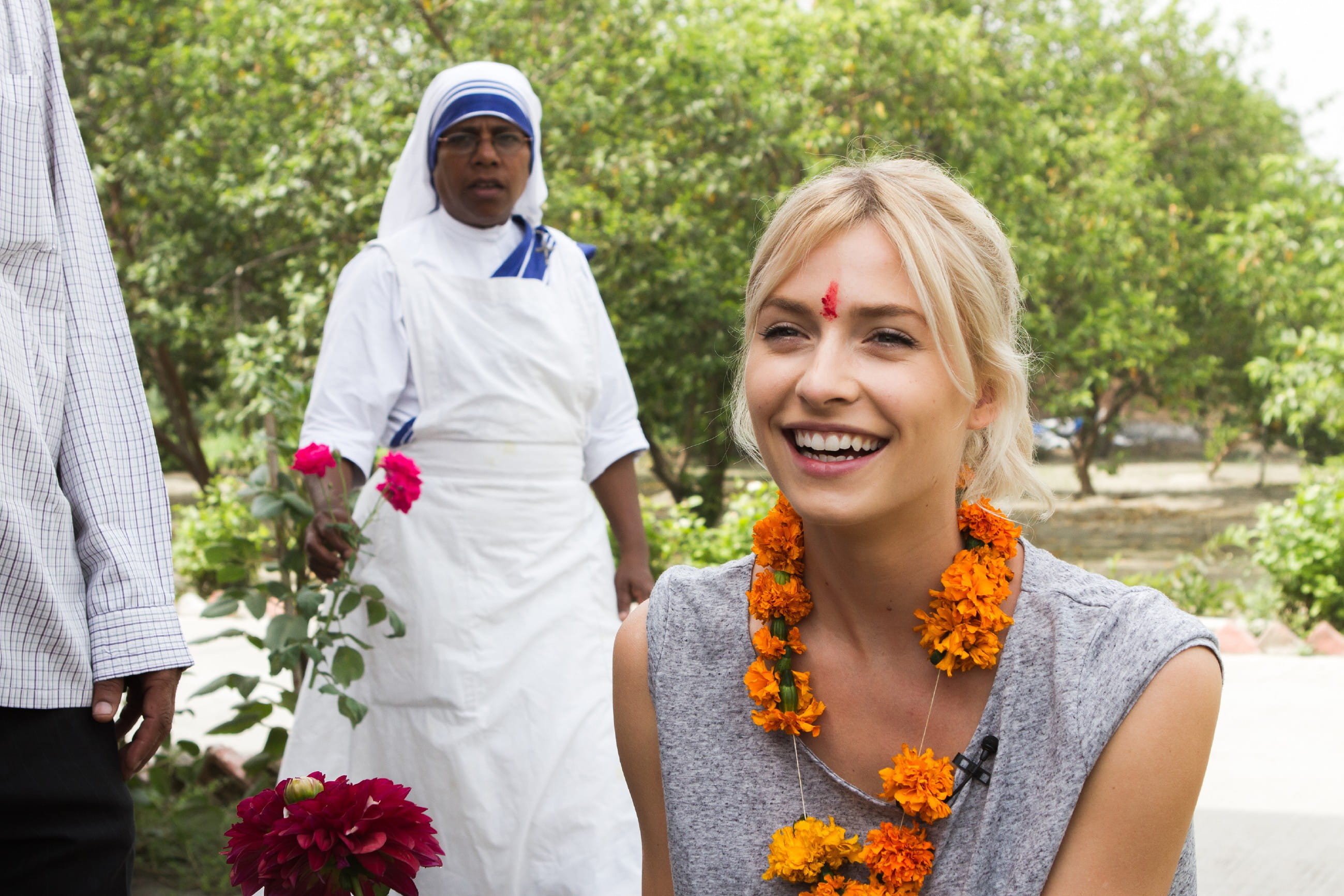 Lena Gercke in Indien lacht und trägt Blumenschmuck