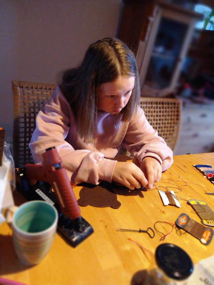 Ein Mädchen sitzt am Tisch und bastelt (Quelle: privat)