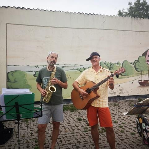 Zwei Freunde gehen per Fahrrad, Gitarre und Saxophon auf Ostseetour