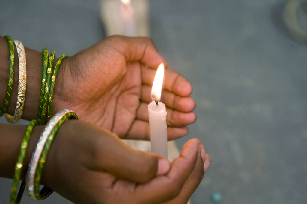 Eine Kinderhand umschließt eine Kerze. (Quelle: Frank Rothe)
