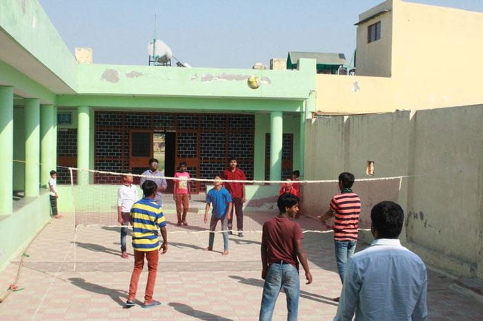 Jungen spielen Volleyball auf einem Hof. (Quelle: Samina Rahim)