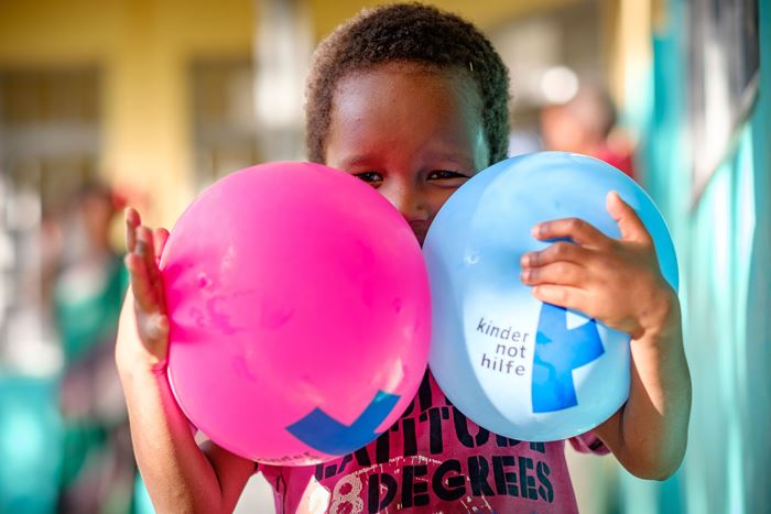 Ein kleines Mädchen hält sich zwei Luftballons vors Gesicht. (Quelle: Jakob Studnar)