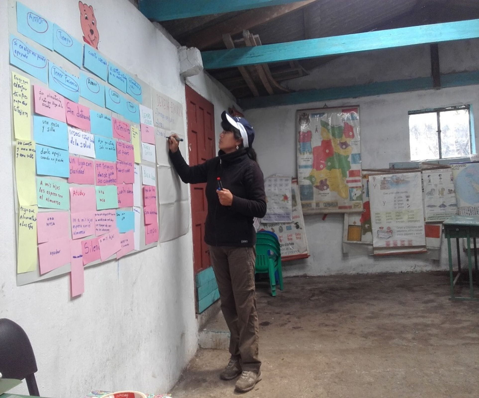 Eine Frau schreibt etwas auf ein Plakat an der Wand. (Quelle: Eva Ziegler)