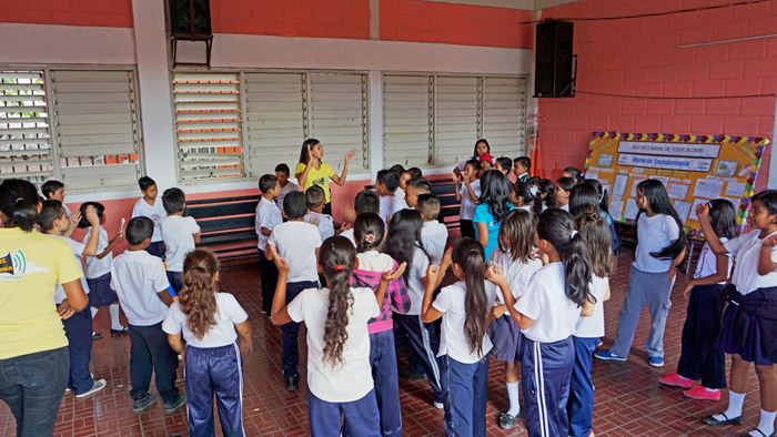 Eine Gruppe Kinder in Honduras singt und klatscht mit einer Betreuerin. (Quelle: Lorenz Töpperwien)