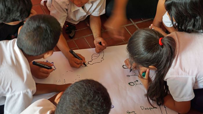 Kinder in Honduras hocken über einem Blatt Papier und malen. (Quelle: Lorenz Töpperwien) Kinder in Honduras hocken über einem Blatt Papier und malen. (Quelle: Lorenz Töpperwien)