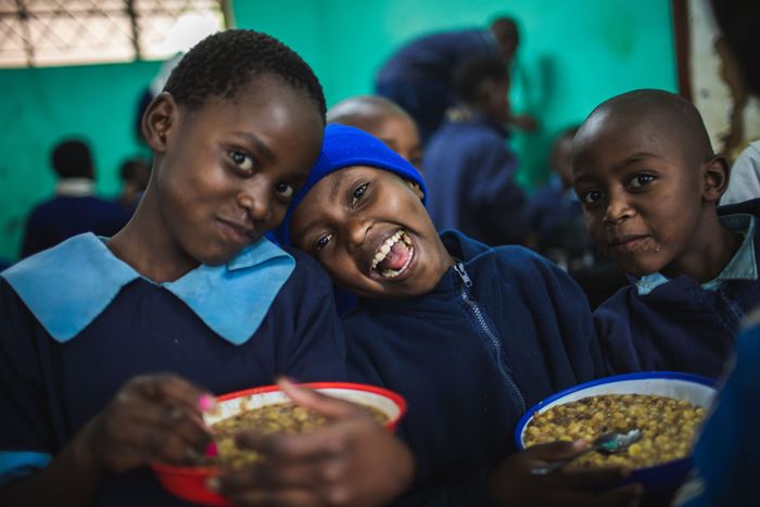 Kinder in Kenia essen und lachen dabei in die Kamera (Bild: Lars Heidrich).