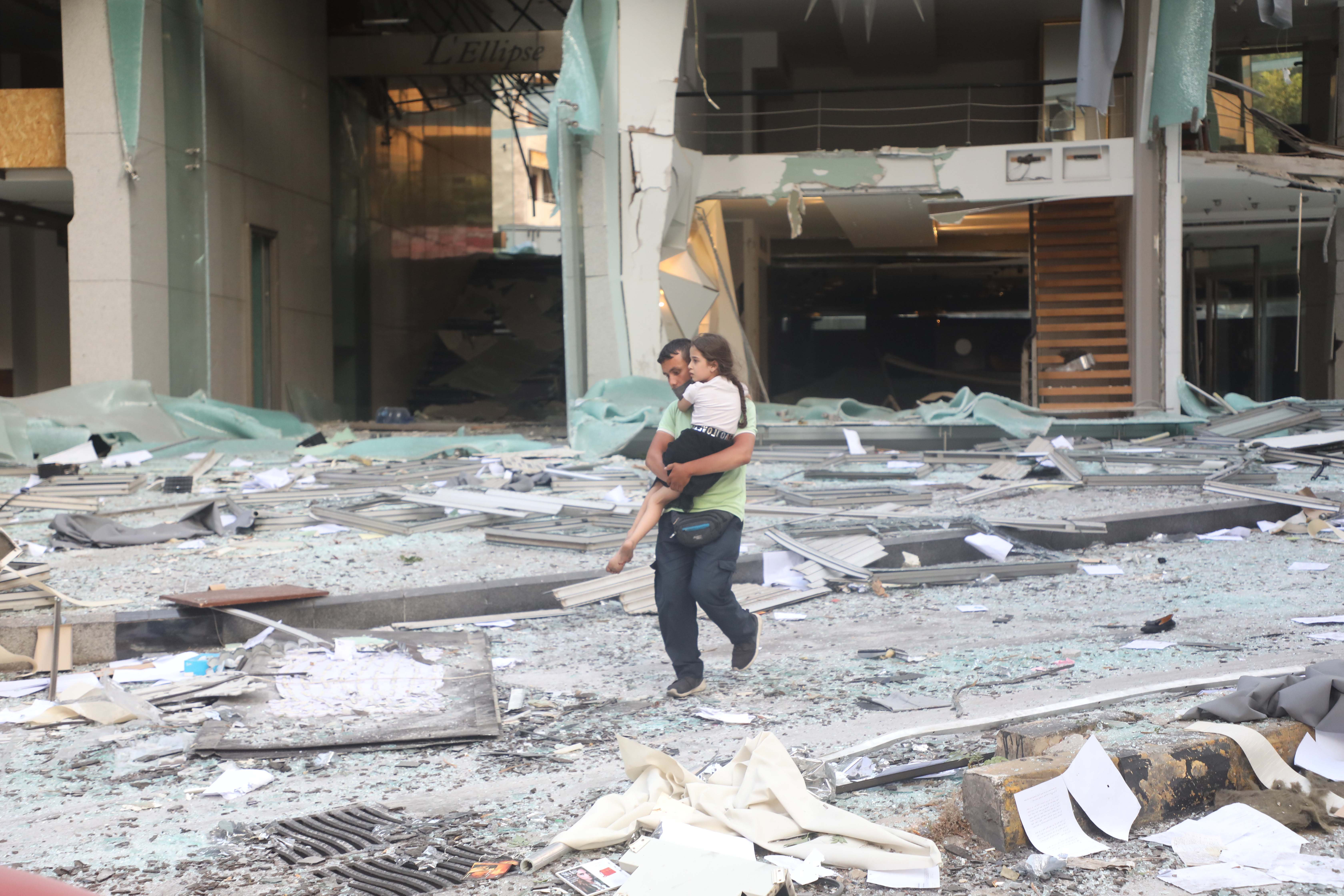Ein Vater trägt seine Tochter durch die Trümmer nach der Explosion (Quelle: DPA)