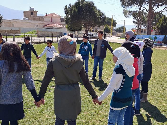 Jugendliche stehen im Kreis auf einer Wiese und halten sich an den Händen. (Quelle: Lorenz Töpperwien) Jugendliche stehen im Kreis auf einer Wiese und halten sich an den Händen. (Quelle: Lorenz Töpperwien)