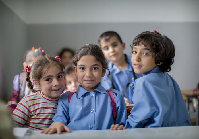 Drei Mädchen in hellblauen Schuluniformen lächeln schüchtern. (Quelle: Jakob Studnar)