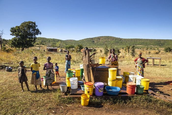 Frauen holen Wasser an einem Brunnen in Sambia. (Quelle: Christian O. Bruch)