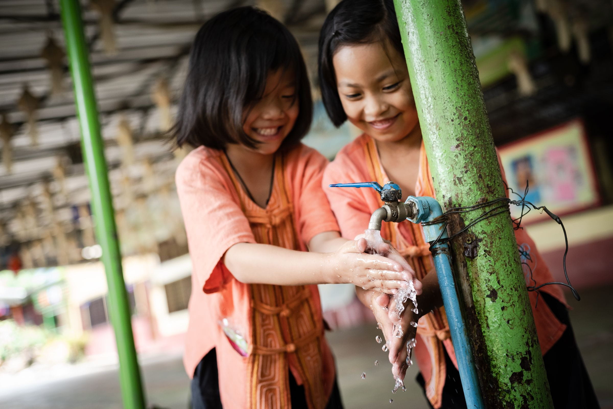 Zwei Mädchen waschen sich die Hände und lachen dabei. (Quelle: Jakob Studnar)