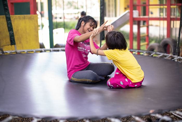 Zwei Mädchen sitzen lachend auf einem Trampolin. (Quelle: Jakob Studnar) Zwei Mädchen sitzen lachend auf einem Trampolin. (Quelle: Jakob Studnar)