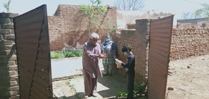 Zwei Erwachsene und ein Kind tragen Schutzmasken und desinfizieren sich die Hände. (Quelle: Kiran Shahzadi)