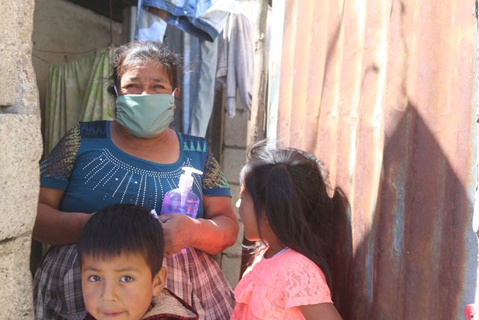 Eine alte Frau und zwei Kinder erhalten Schutzmasken. (Quelle: Thomas Hartig)