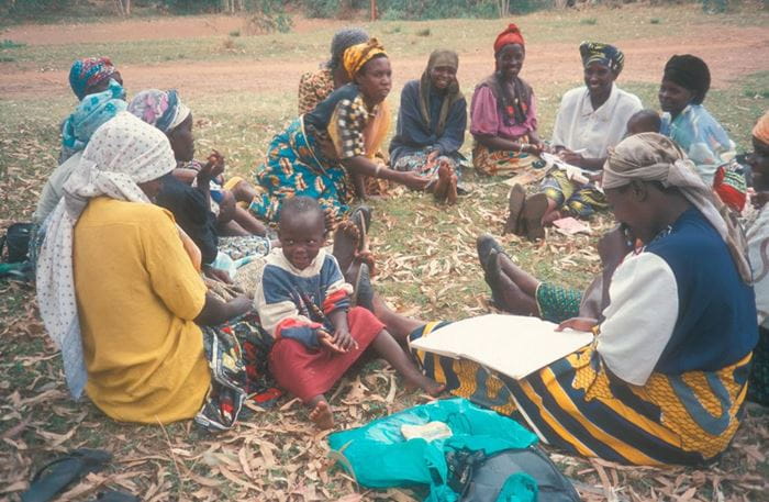 Frauen der Selbsthilfegruppe sitzen im Kreis in Ruanda. (Quelle: Anette Drost)