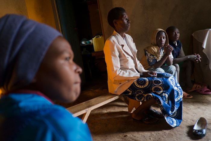 Eine Frau aus Ruanda sitzt auf einer Bank und erzählt ihre Geschichte anderen Teilnehmerinnen der Selbsthilfegruppe. (Quelle: Jakob Studnar)