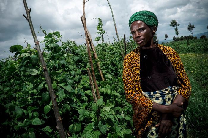 Eine Frau aus Ruanda steht auf ihrem Feld. (Quelle: Jakob Studnar)
