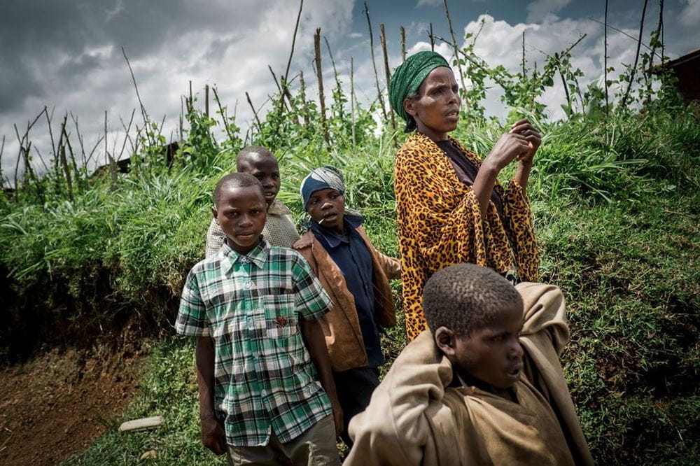 In Ruanda steht eine Frau mit ihren Kindern auf einem Feld. (Quelle: Jakob Studnar)