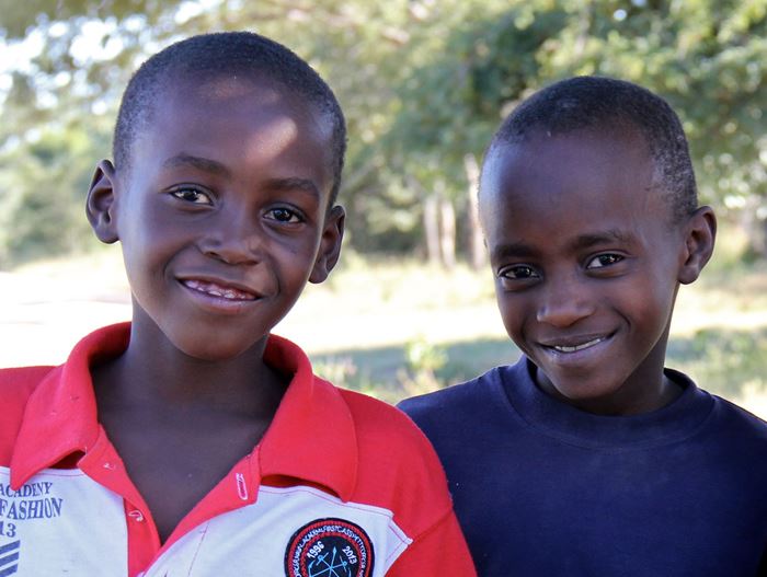 Zwei Jungen in Simbabwe stehen nebeneinander und schauen in die Kamera. (Quelle: Wiebke Weinandt)