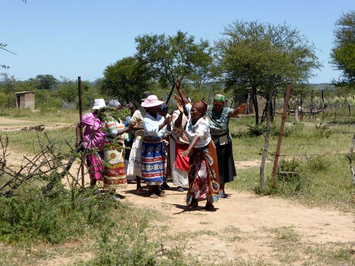Eine Gruppe Frauen in Simbabwe laufen über ihre Felder. (Karl Pfahler)