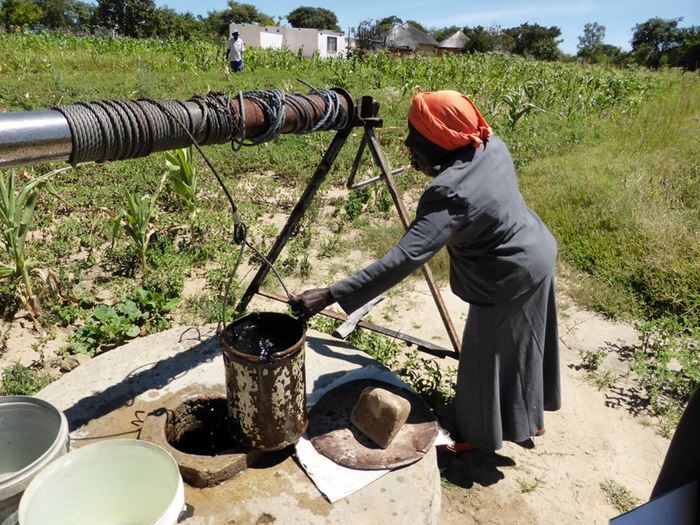 Eine Frau in Simbabwe holt Wasser aus einem Brunnen. (Karl Pfahler)