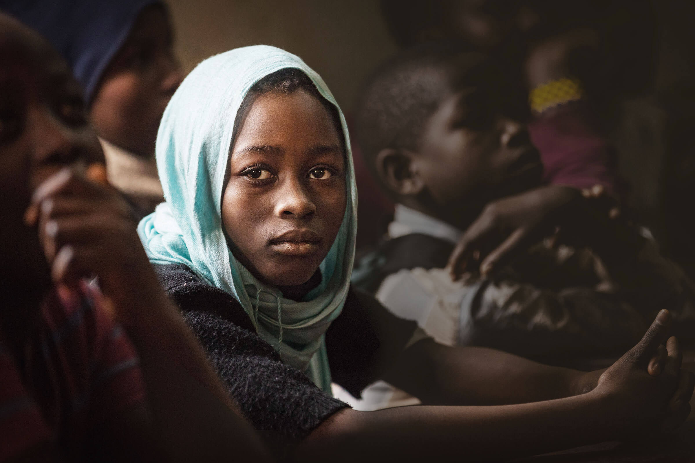 Ein afrikanisches Mädchen mit Kopftuch schaut nachdenklich in die Kamera. (Quelle: Lars Heidrich)