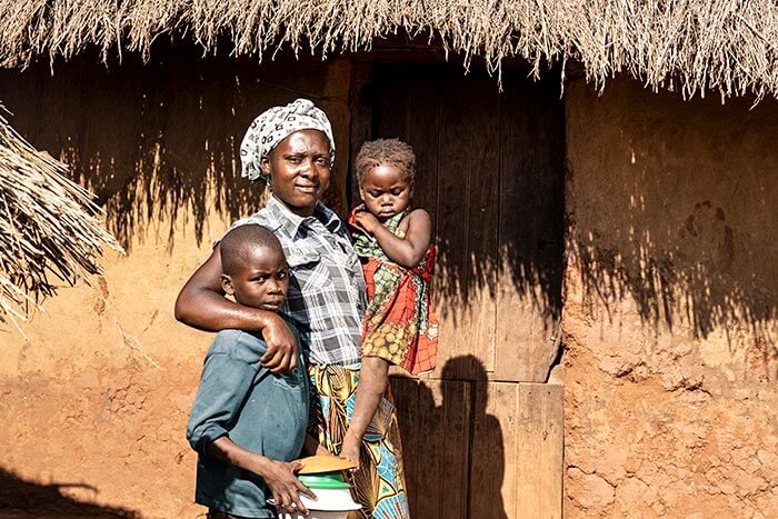Eine Mutter aus Sambia hält ihre zwei Kinder im Arm. (Quelle: Kindernothilfe)