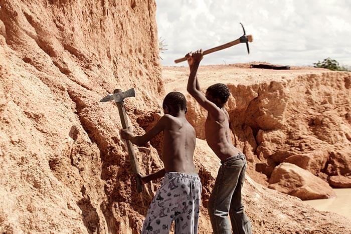 Zwei Jungen aus Sambia hacken mit Spitzhacken auf Felsen ein.  (Quelle: Kindernothilfe)