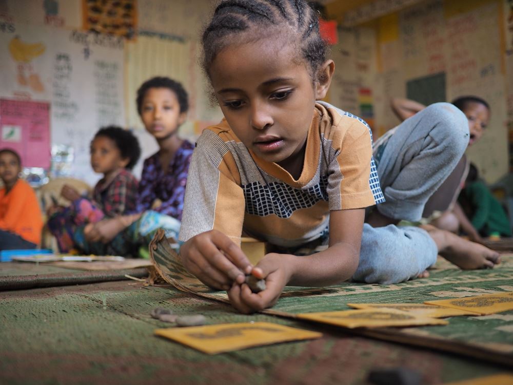 Ein Kindergartenkind aus Äthiopien sitzt auf dem Boden und spielt. (Quelle: Malte Pfau)