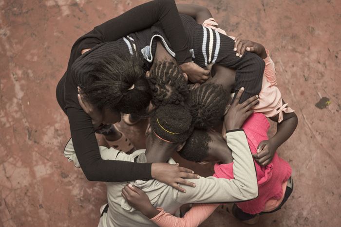 Mädchen des Schutzhauses in Kenia stehen im Kreis und umarmen sich. (Quelle: Christian Nusch)