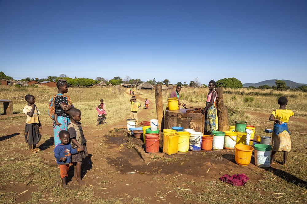 Frauen holen an einem Brunnen ausserhalb des Dorfes Wasser für den taeglichen Bedarf. Quelle: Christian O. Bruch